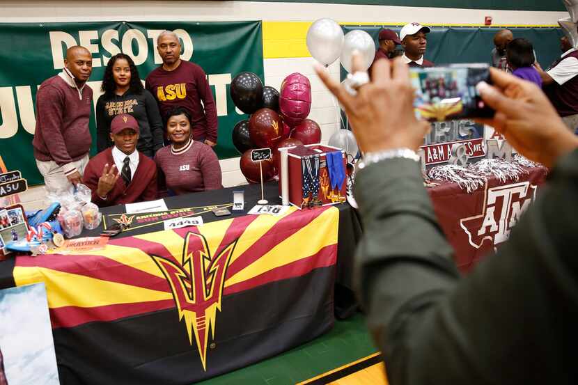 Track athlete Jalen Drayden poses for a photograph with his family after signing with...