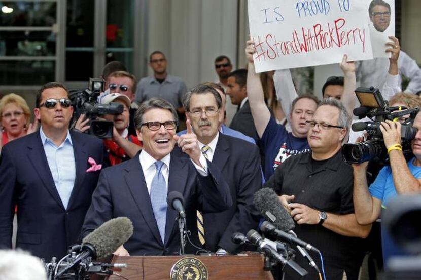 Gov. Rick Perry acknowledged supporters as he stepped up to speak to the media before...