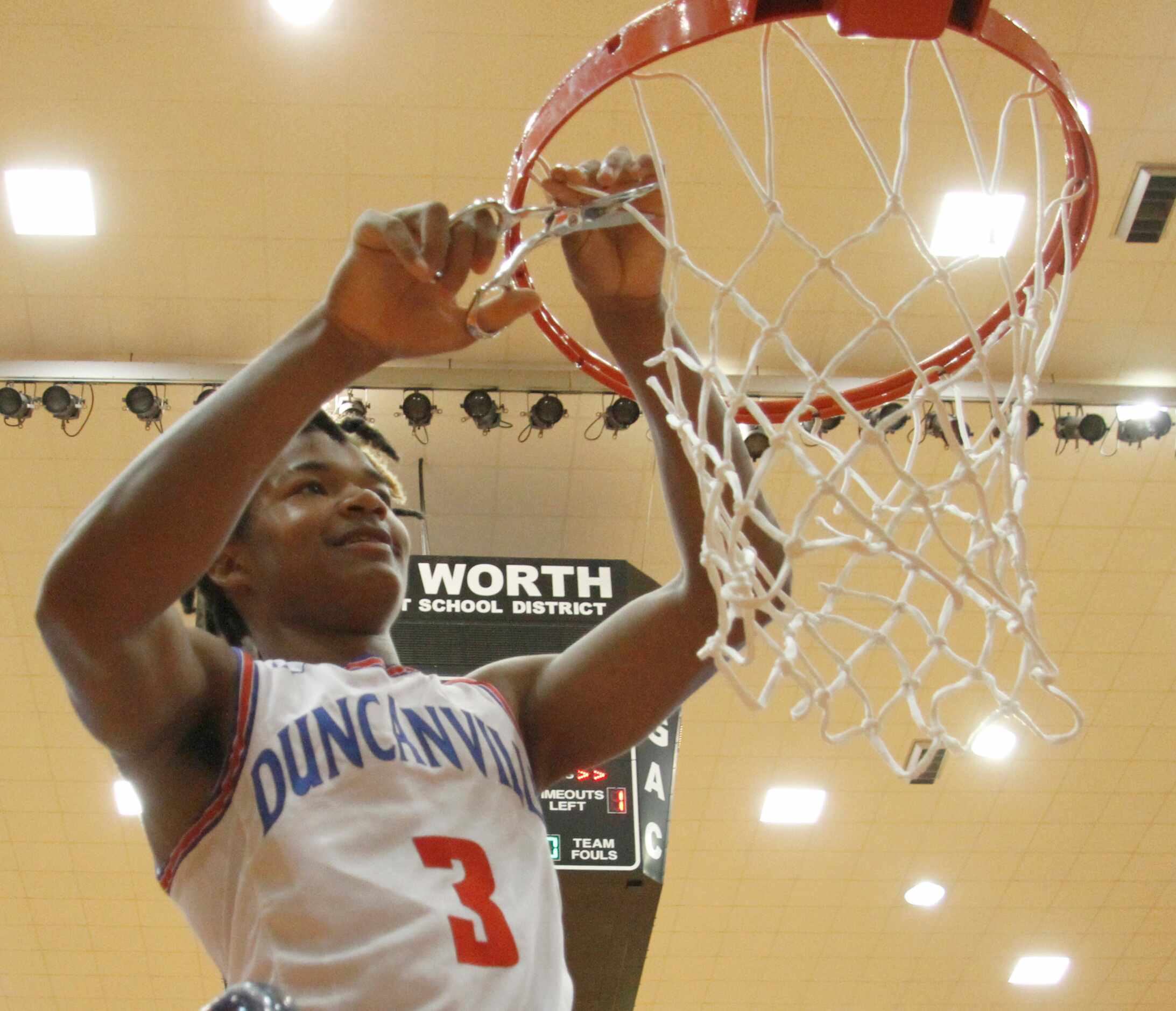 Duncanville guard C.J. Ford (3) was all smiles as he cuts a portion of the net from the rim...