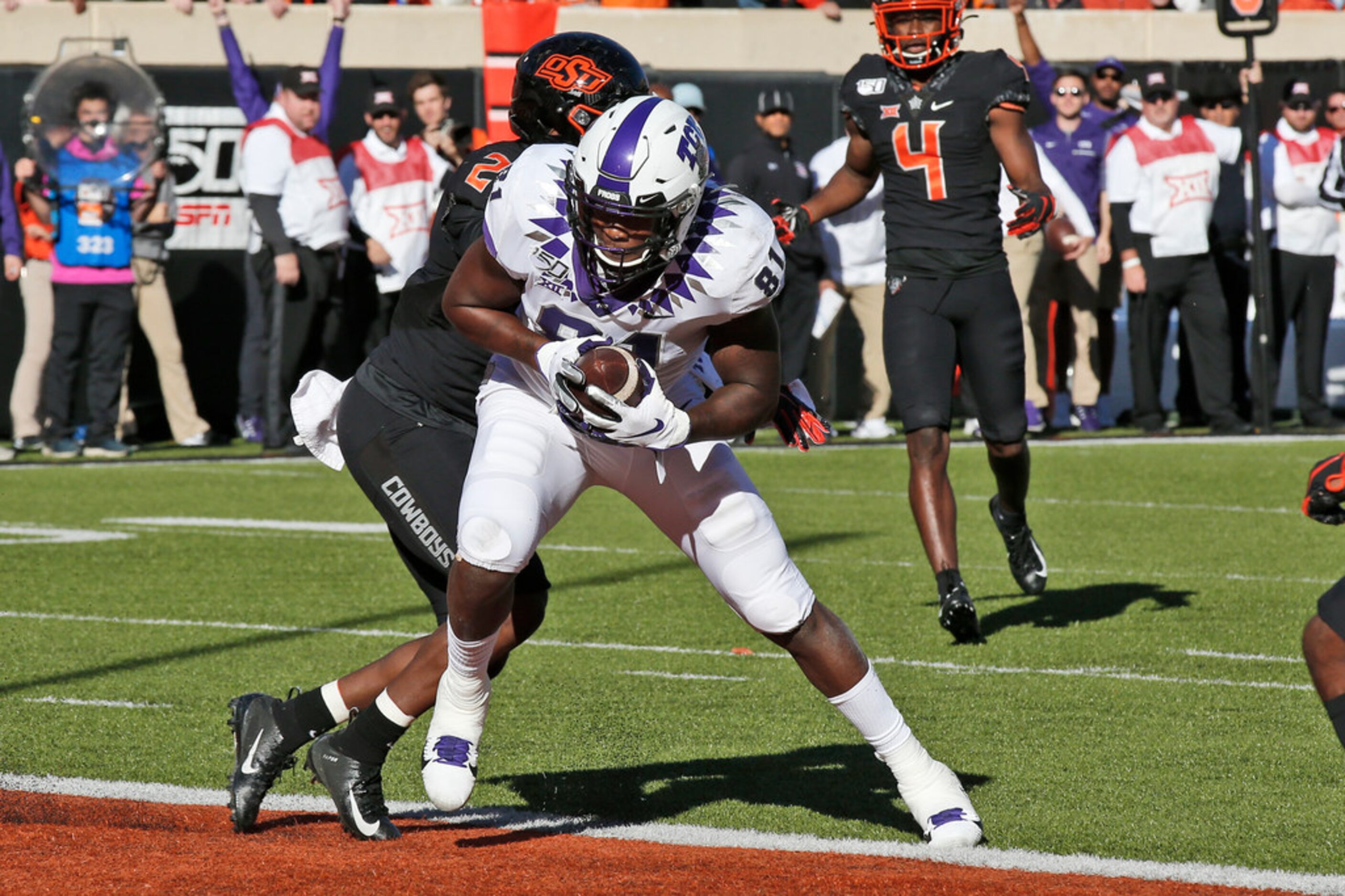 TCU tight end Pro Wells (81) scores in front of Oklahoma State safety Tanner McCalister (2)...