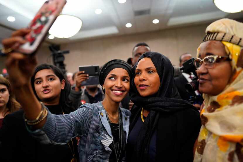 Ilhan Omar (left) poses for selfies with supporters after her victory Nov. 6, 2018, in...