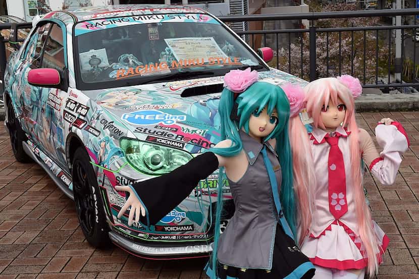 Japanese "anime" fans, wearing masks and costumes of animation characters Miku Hatsune (L)...