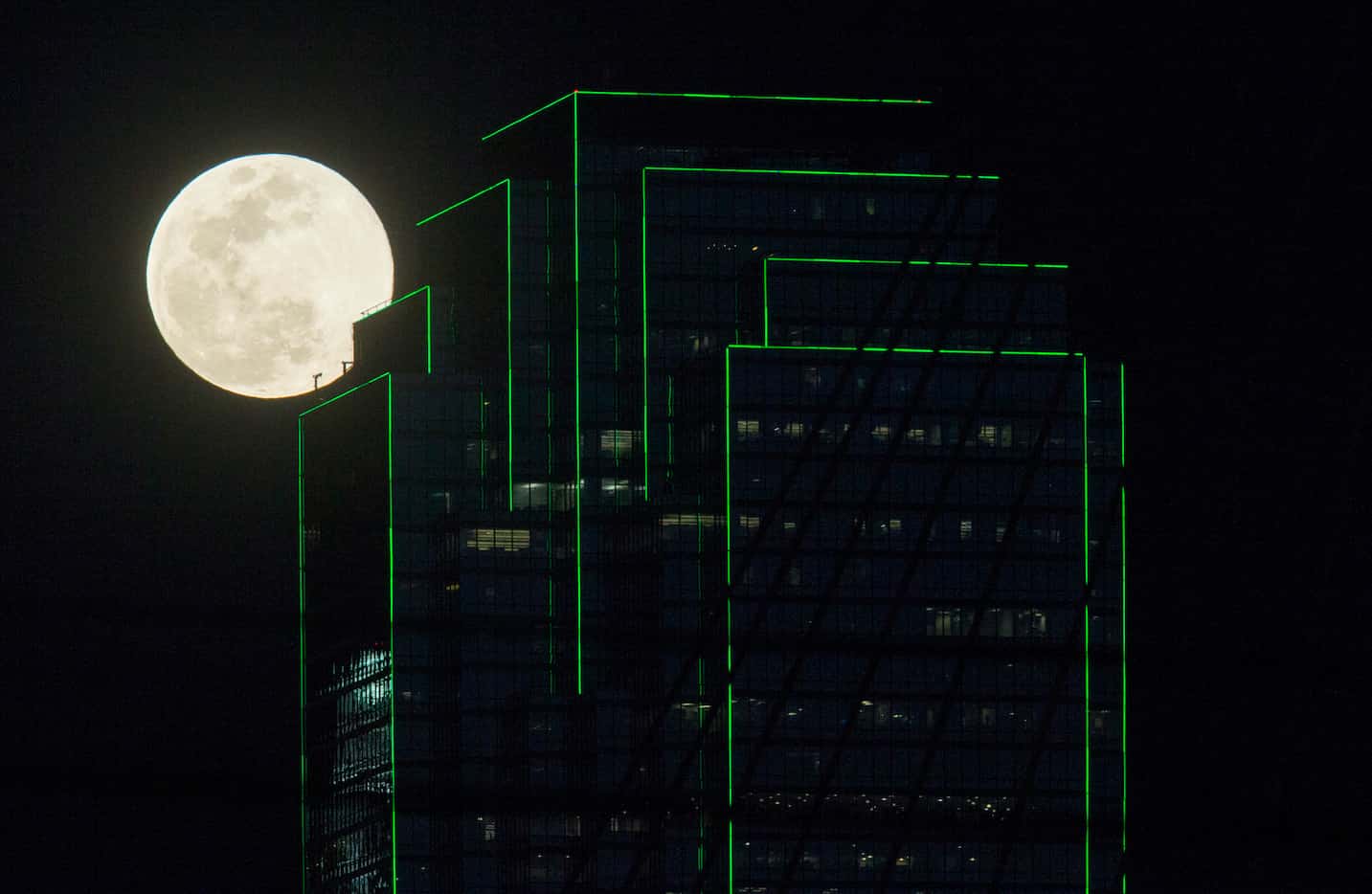 A full "worm" moon supermoon rises near the Bank of America building on March 20 in downtown...