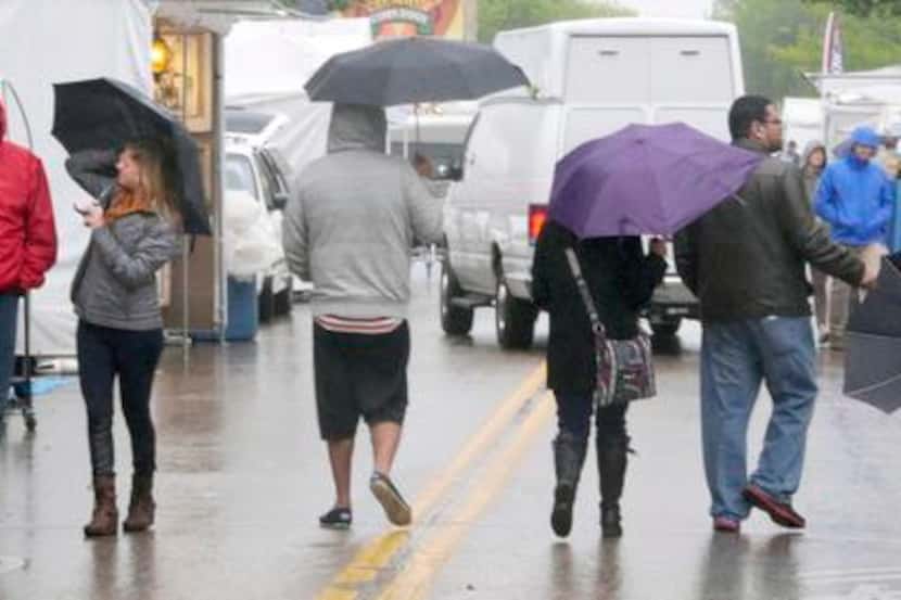 Festivalgoers  made their way through the rainy streets Sunday afternoon at the Deep Ellum...
