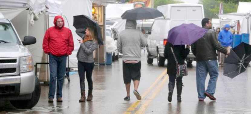 Festivalgoers  made their way through the rainy streets Sunday afternoon at the Deep Ellum...