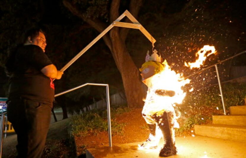 Leroy Peña quema una piñata del presidente Donald Trump al final de una protesta organizada...