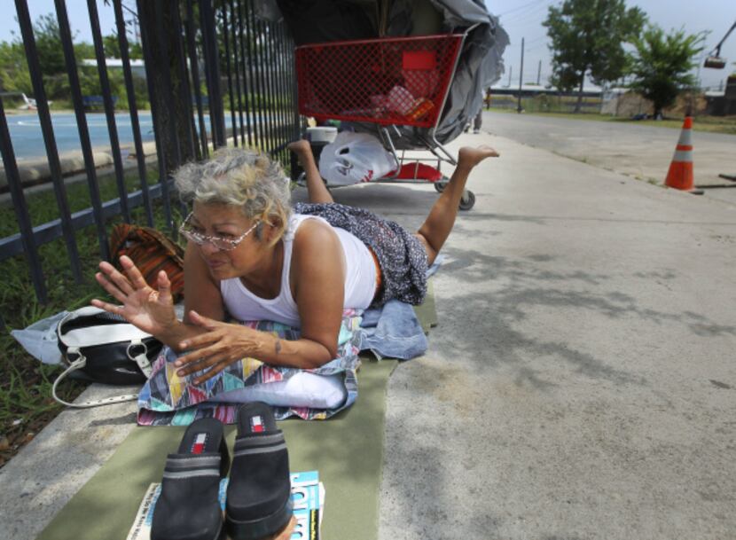 Julie Garcia said she hangs out on the sidewalk near the Austin Street Shelter because she...