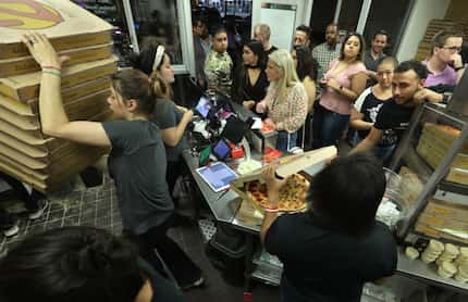 Employees prepare a steady flow of pizza during a 2 a.m. rush at Zalat Pizza in Dallas. We...