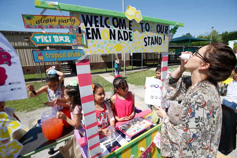 Erin Spurgeon drinks a lemonade sample from the Michelle Obama Lemonade Stand as students...