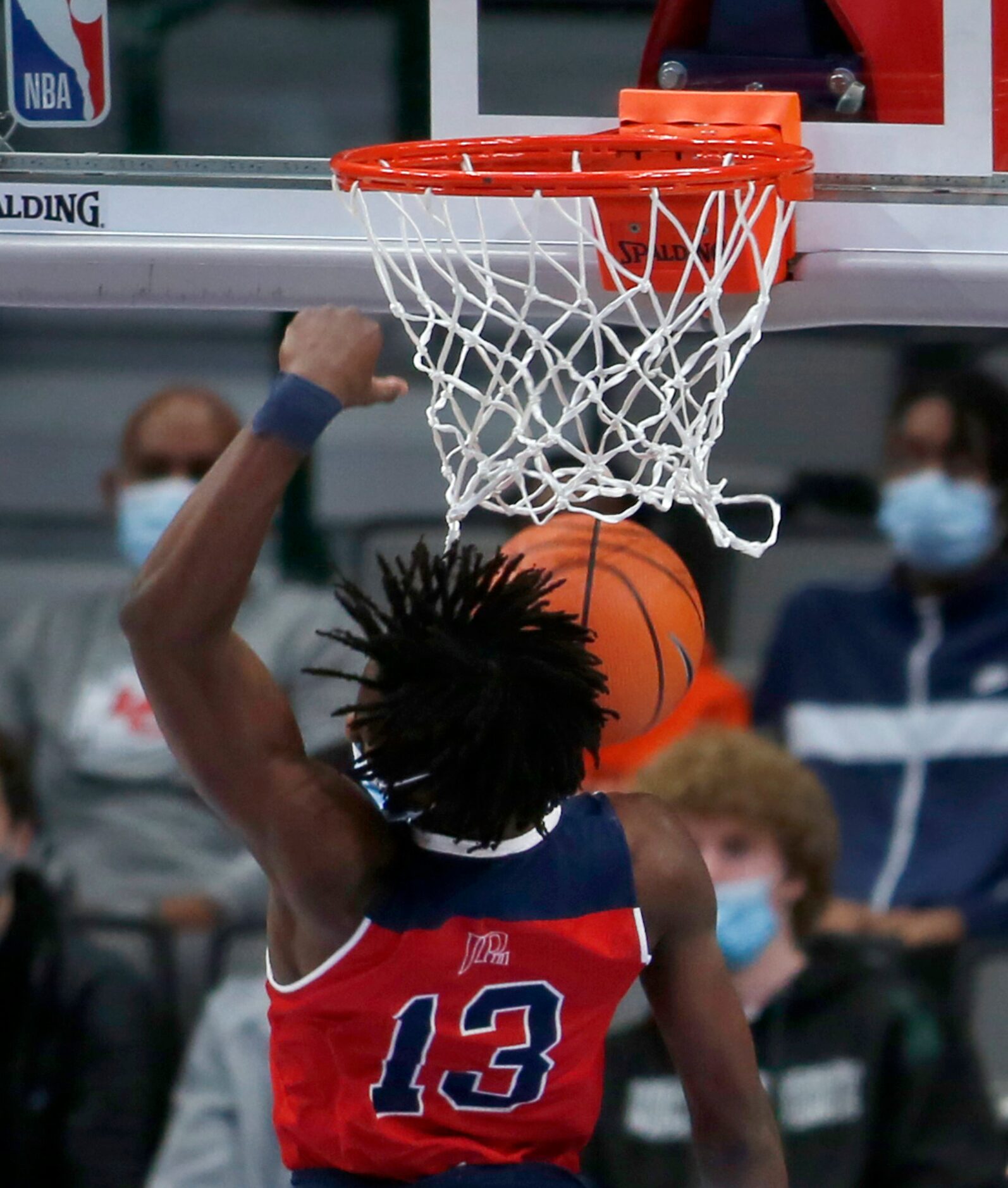 Plano John Paul ll senior Manny Obaseki (13) catches the residual from a first half dunk in...