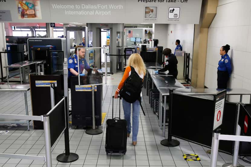 A passenger makes her way through a TSA security checkpoint at DFW International Airport on...
