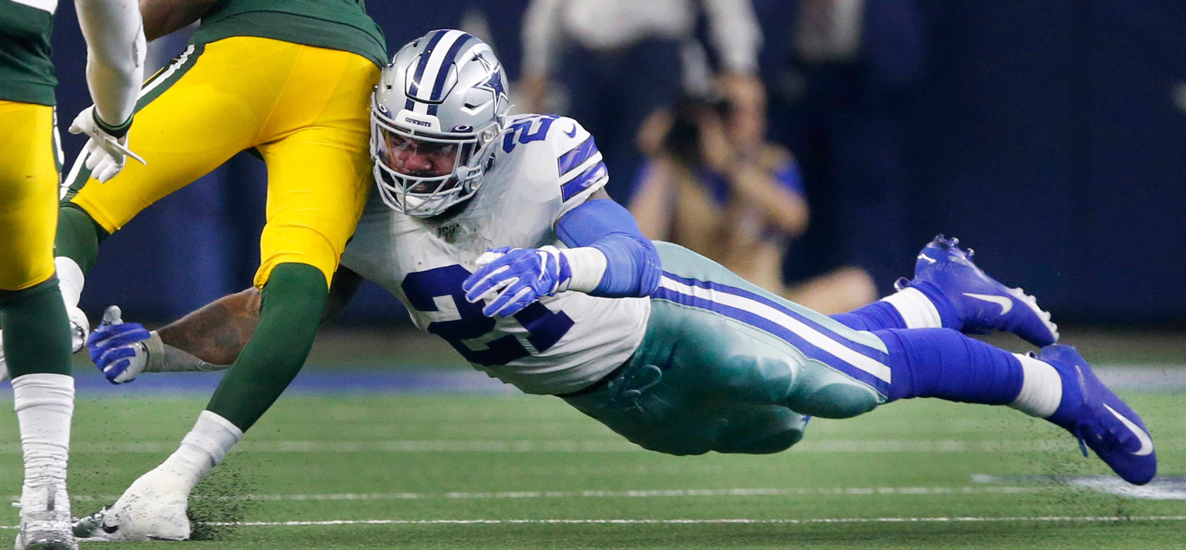 Dallas Cowboys running back Ezekiel Elliott (21) is forced to tackle Green Bay Packers...