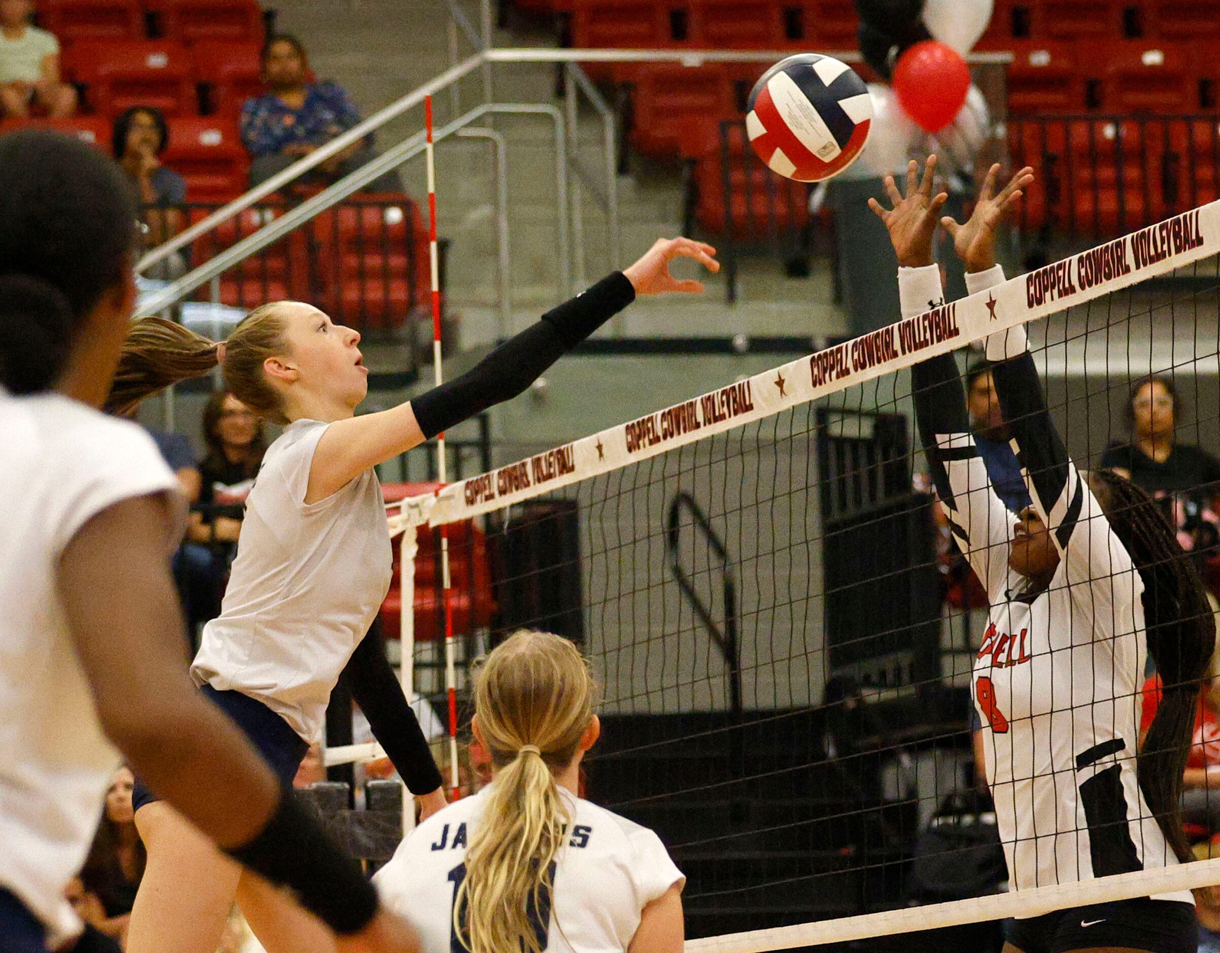 Flower Mound's Caroline Tredwell (4), left, spikes the ball as Coppell's Daki Kahungu (8)...