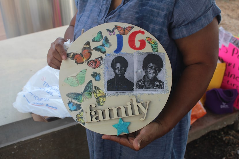 Activist Olinka Green holds a plaque honoring George and Johnny Johnson at Dallas Police...