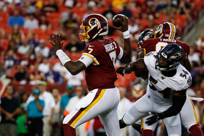 Washington Redskins quarterback Dwayne Haskins (7) throws the ball under pressure from...