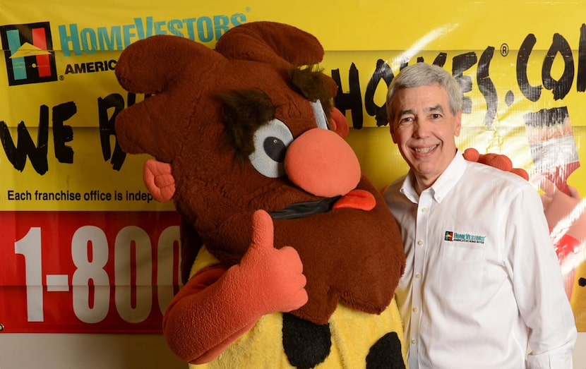 HomeVestors CEO David Hicks and the company's caveman mascot.