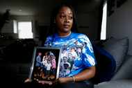 Yadira Campbell poses for a photo holding a family photo which includes her 16-year-old son,...