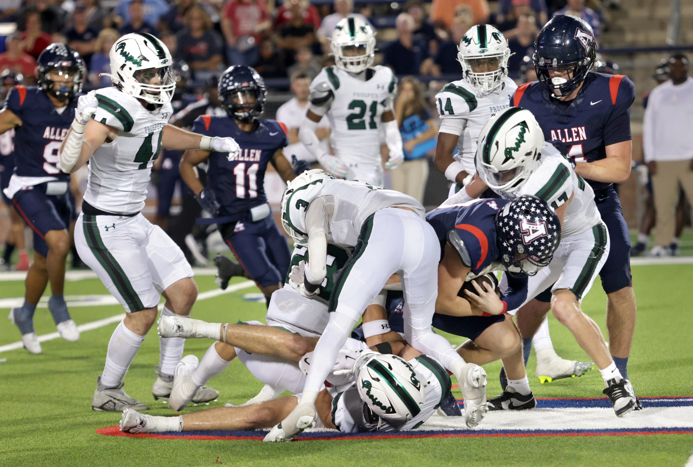 Allen player #7 Brady Bricker is stopped by a wall of Prosper players during the Prosper...