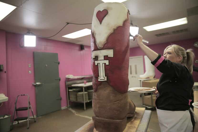 Bronwen Weber adds some cocoa powder to the 47-inch-tall boot cake to give it a rustic,...
