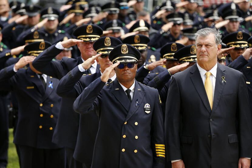 Dallas police Chief David Brown (center, left) salutes as Dallas Mayor Mike Rawlings (right)...
