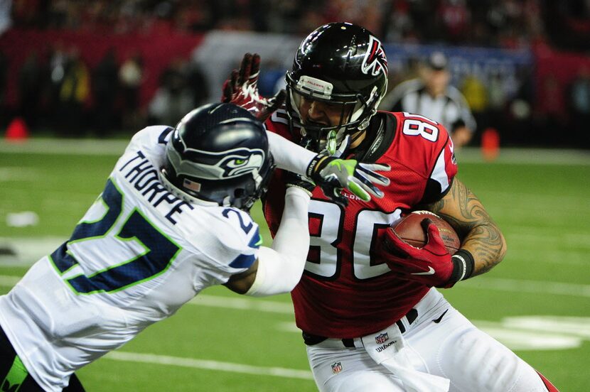 ATLANTA, GA - JANUARY 14:  Levine Toilolo #80 of the Atlanta Falcons stiff arms Neiko Thorpe...