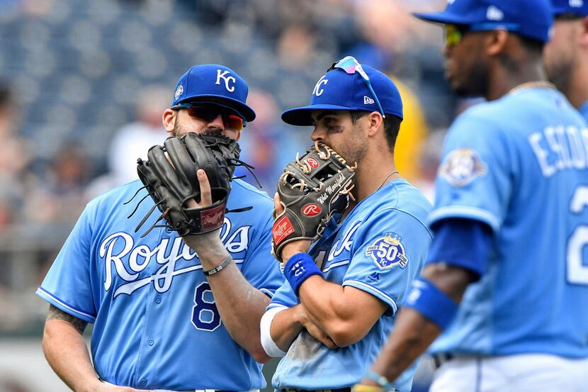 Kansas City Royals third baseman Mike Moustakas and second baseman Whit Merrifield talk in...