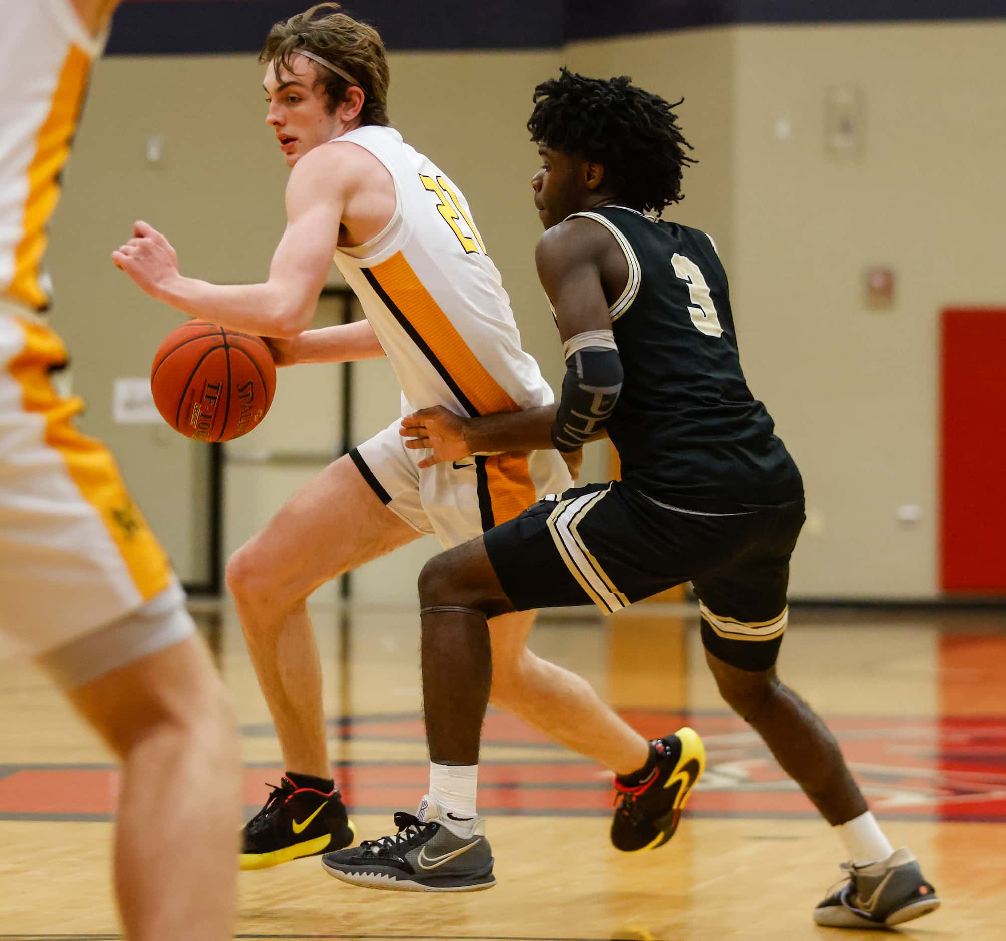 Memorial High School Drew Steffe (21) dribbles the ball up the court while The Colony High...