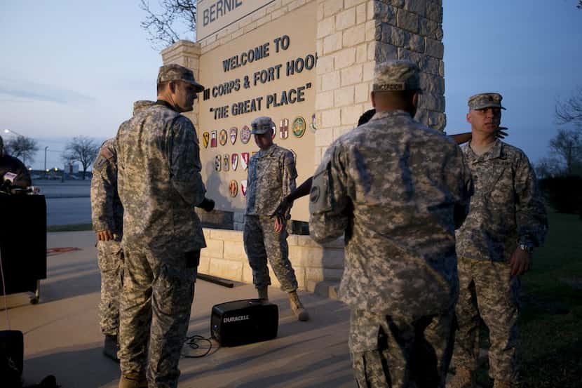Military personnel wait for a news conference to begin Wednesday evening at Fort Hood after...