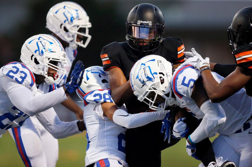 Lancaster running back Tre Bradford (2) is wrapped up by Duncanville defenders Omari Abor...