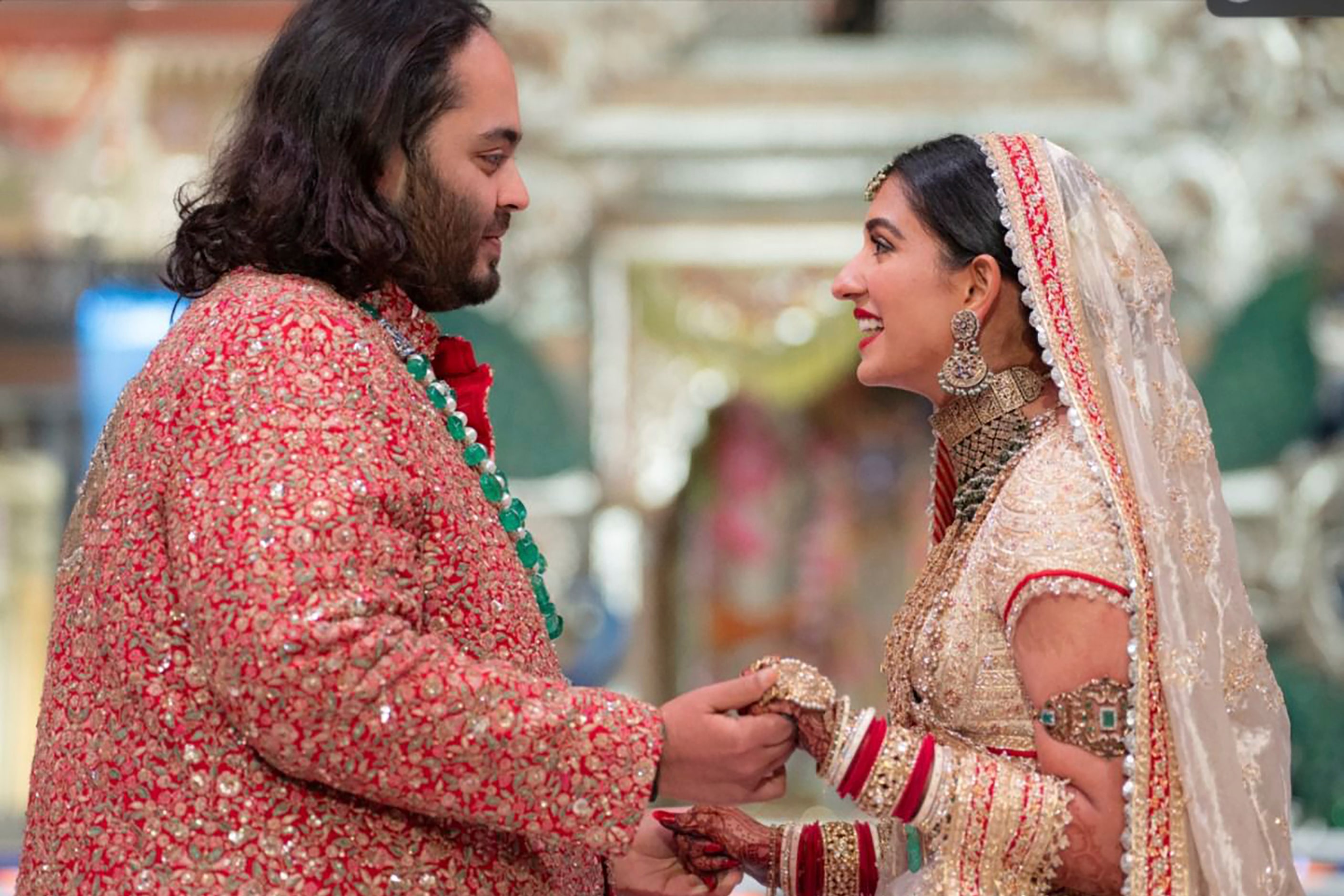 Anant Ambani, left, the son of billionaire Mukesh Ambani, holds hands with Radhika Merchant...