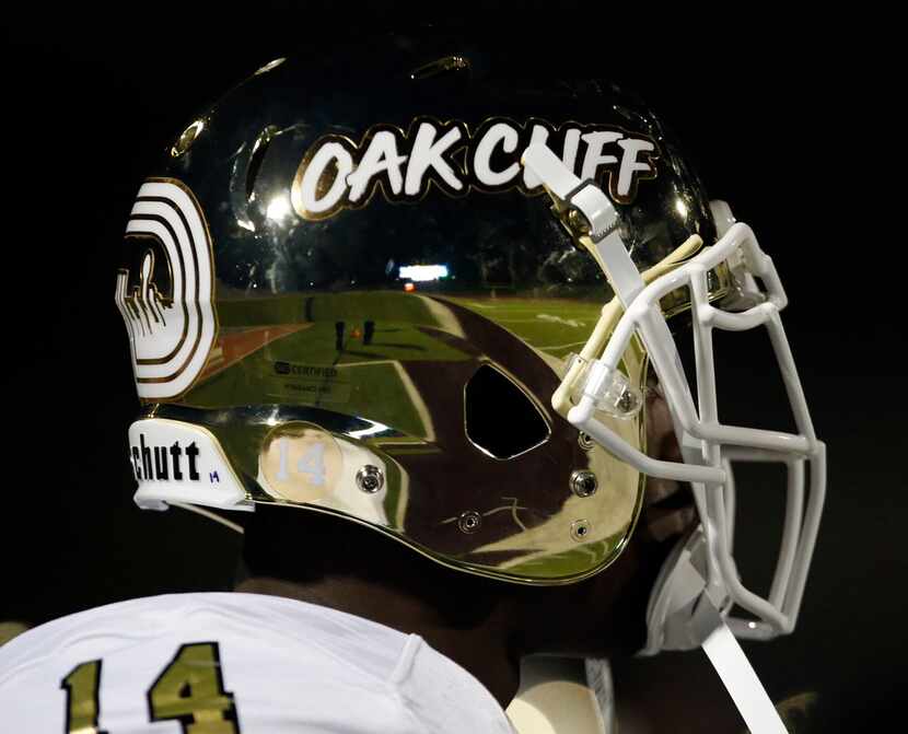 The South Oak Cliff players sport shinny gold helmets with the words Oak Cliiff of the side...