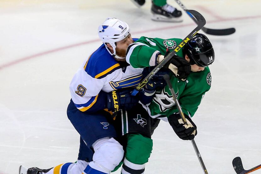 The Dallas Stars' Jamie Benn, right, gets tangled up with the St. Louis Blues' Steve Ott (9)...
