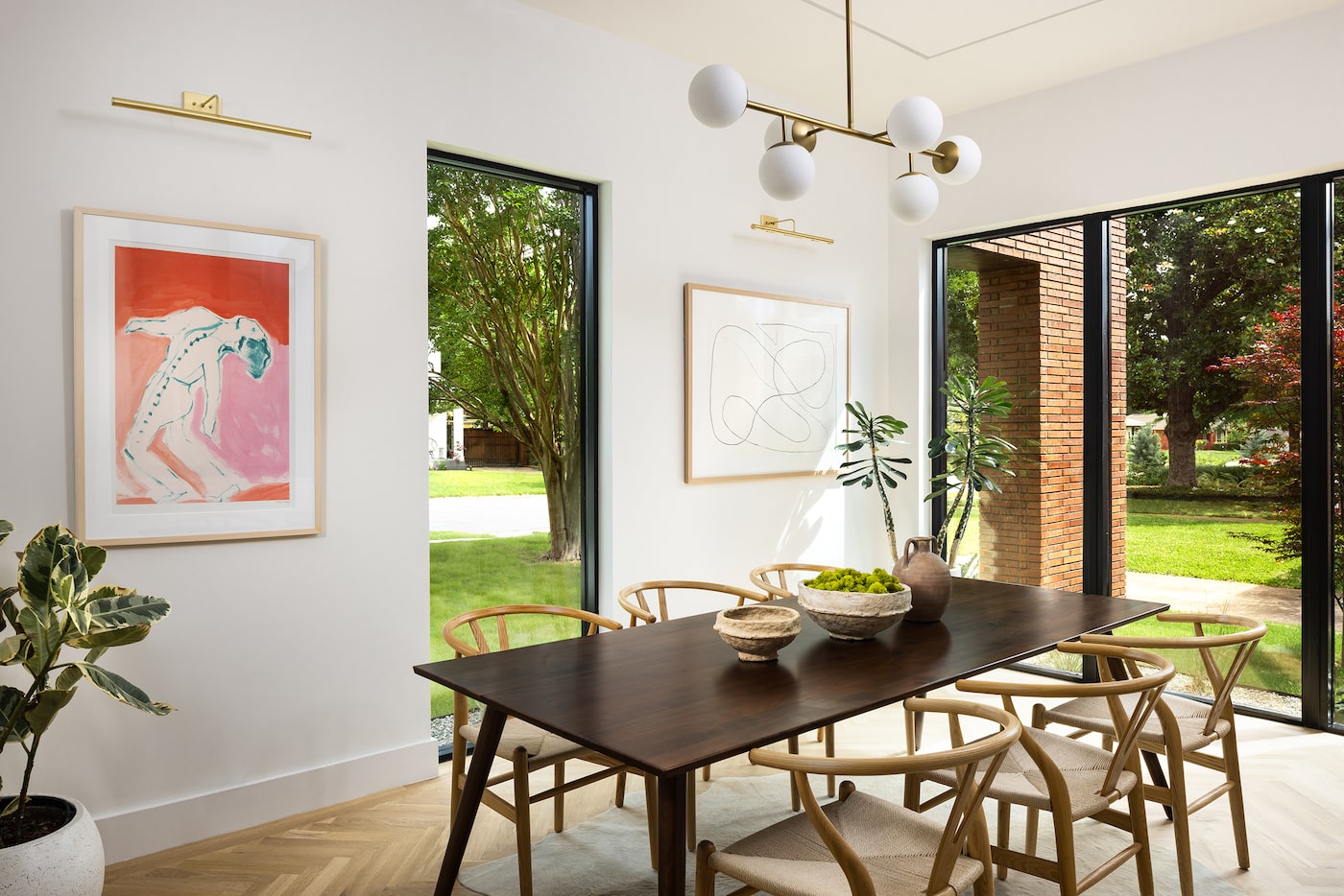 Dining room with a midcentury modern aesthetic, where a walnut table is surrounded by...