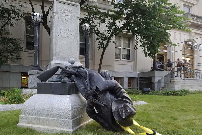 A toppled Confederate statue lies on the ground on Monday, Aug. 14, 2017, in Durham, N.C....