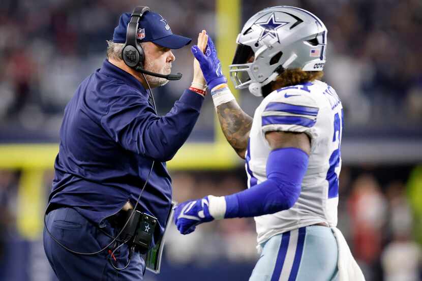 Dallas Cowboys head coach Mike McCarthy slaps hands with Dallas Cowboys running back Ezekiel...