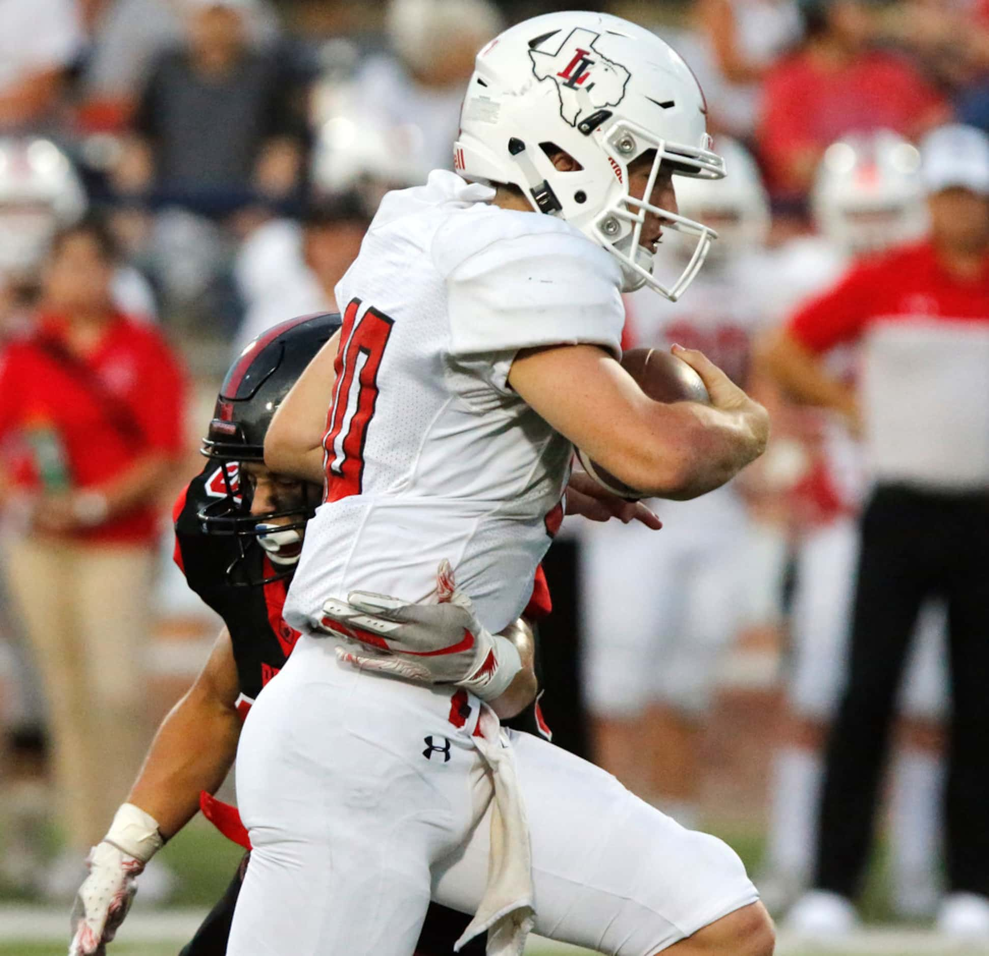 Lovejoy High School quarterback Ralph Rucker (10) breaks through the tackle attempt by...