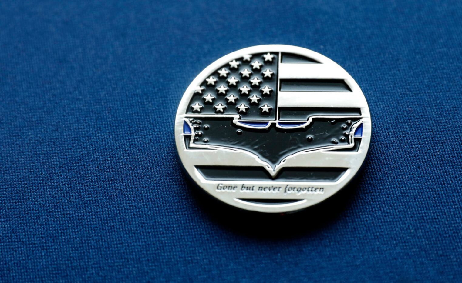 DART Officer Joseph Kyser carries a challenge medal depicting the Batman logo after fallen...