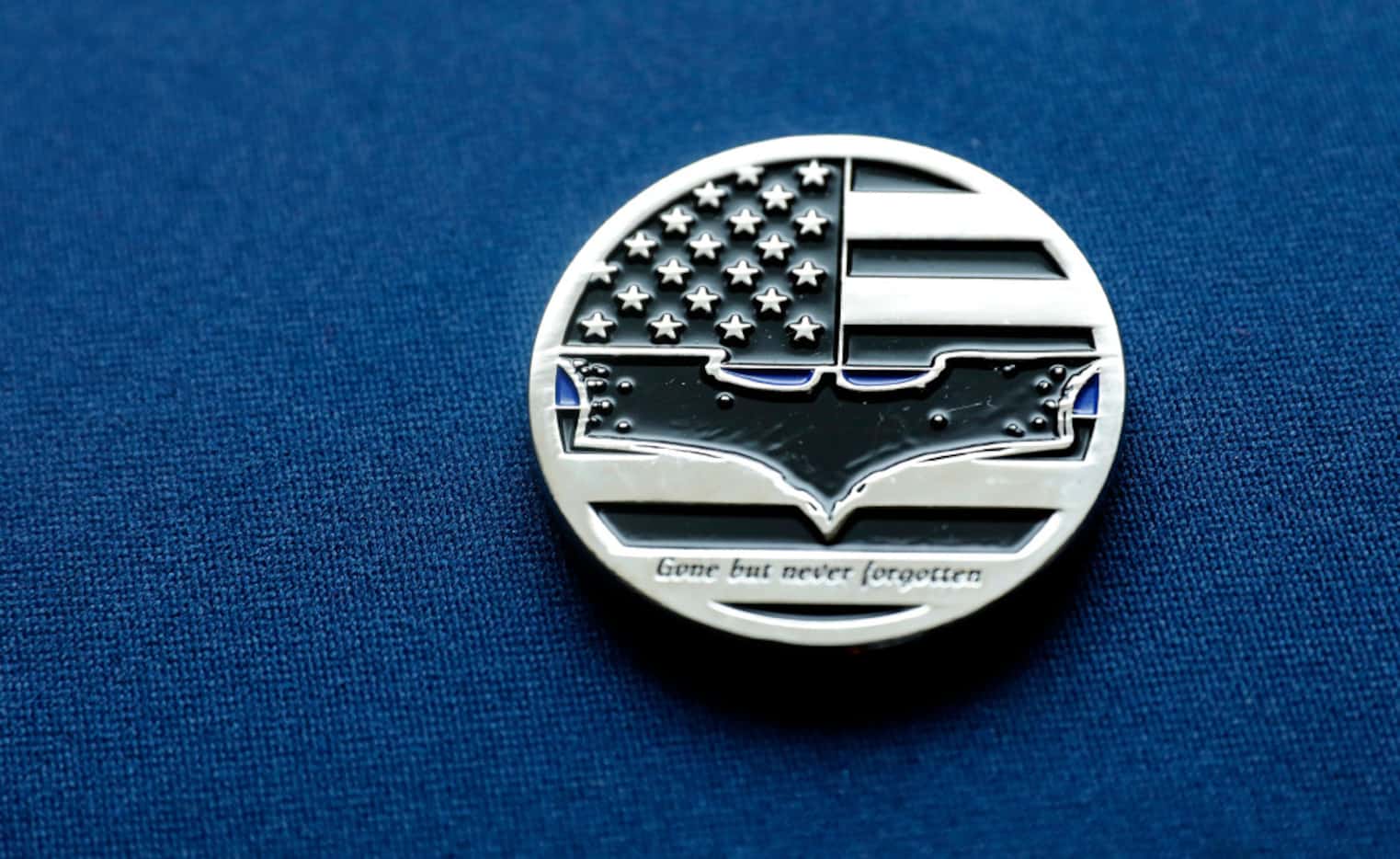 DART Officer Joseph Kyser carries a challenge medal depicting the Batman logo after fallen...