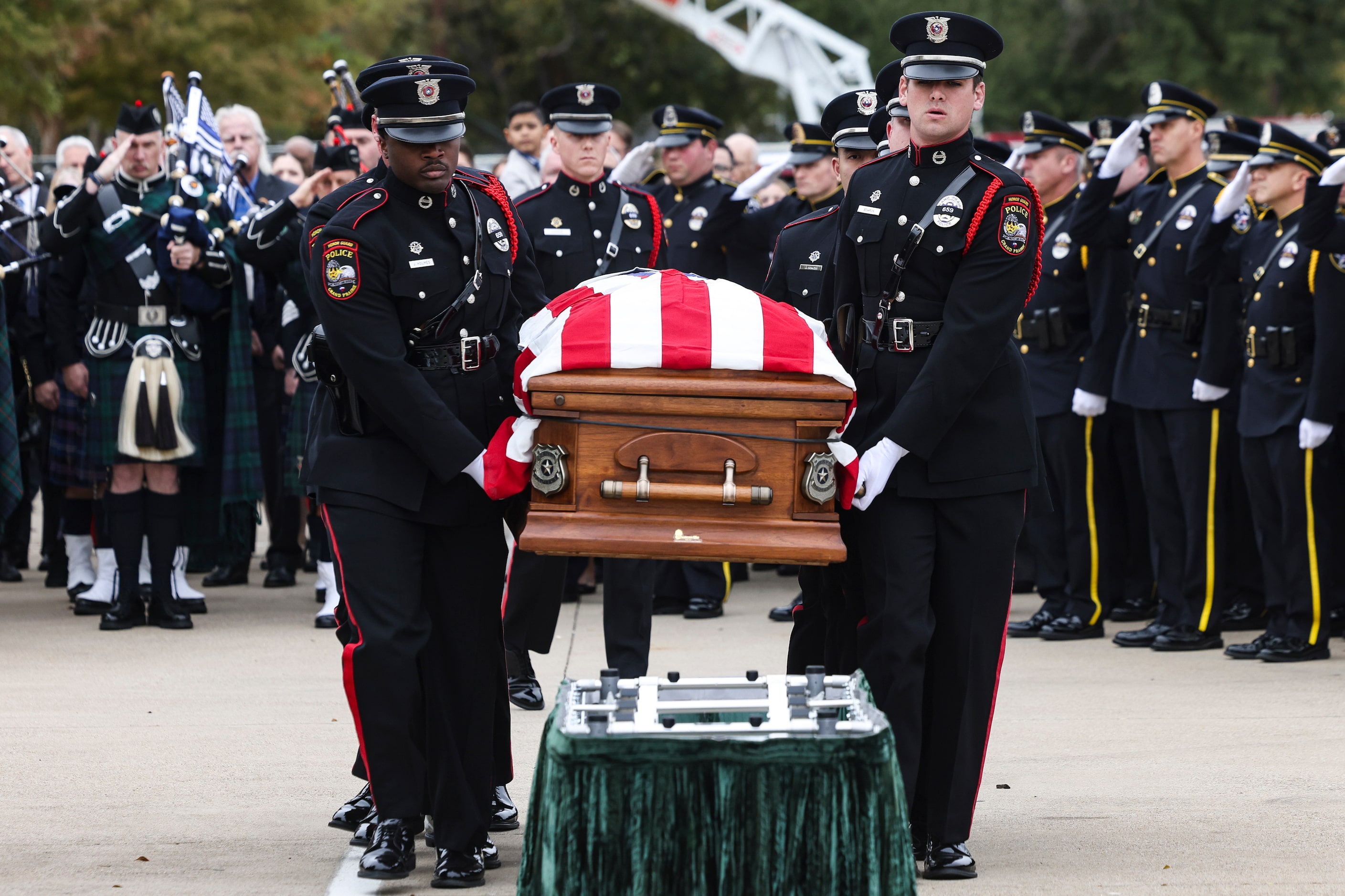 Grand Prairie Police Department Honor Guard members walk holding the casket of Grand Prairie...