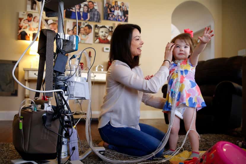 Christina Gregory, 2, has to wear a diaphragmatic pacemaker in a backpack to keep her...