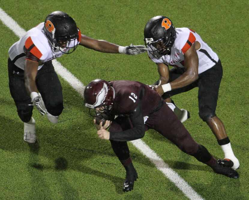 Rowlett quarterback Logan Bonner (12) is sacked for a loss as he is unable to elude the...
