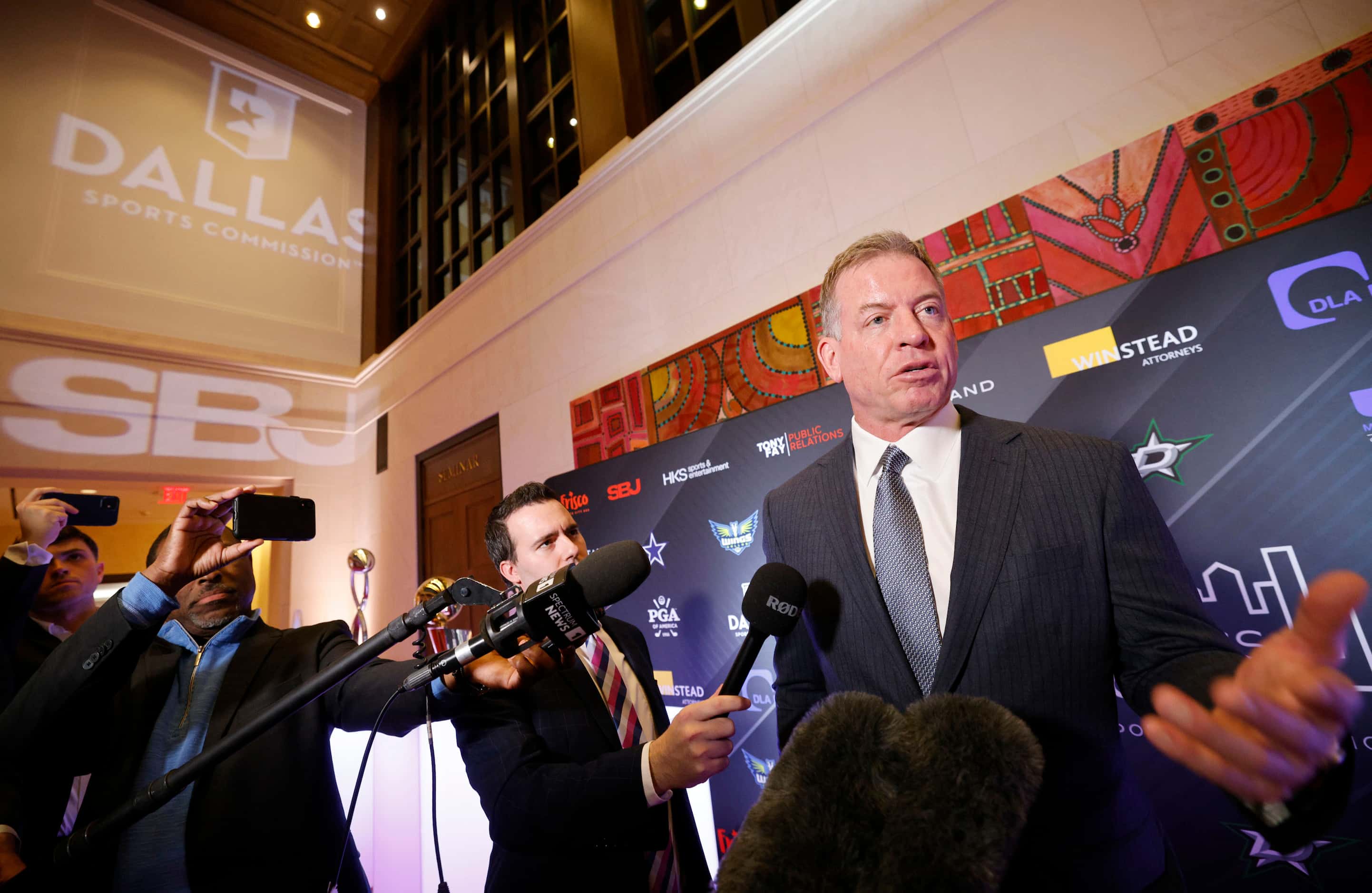 Pro Football Hall of Famer Troy Aikman, right, talks to reporters on the red carpet during a...