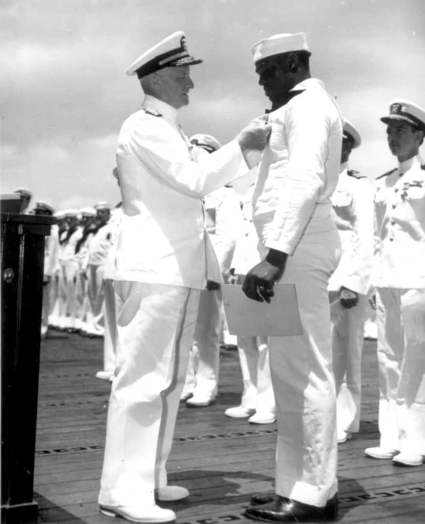 Adm. Chester W. Nimitz pins the Navy Cross on the uniform of Doris "Dorie" Miller of Waco,...