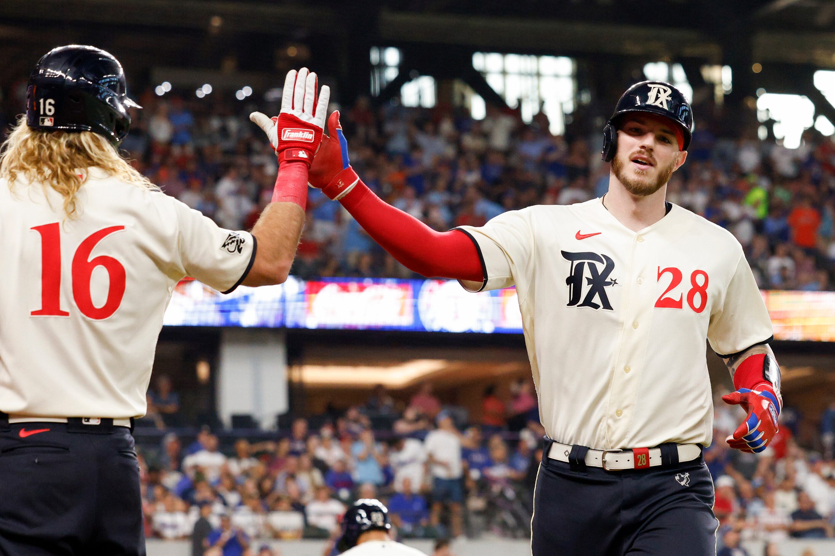 Texas Rangers catcher Jonah Heim (28) high-fives left fielder Travis Jankowski (16) after a...