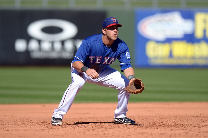 Texas Rangers first baseman Mike Olt fields a hit by San Diego Padres second baseman Orlando...