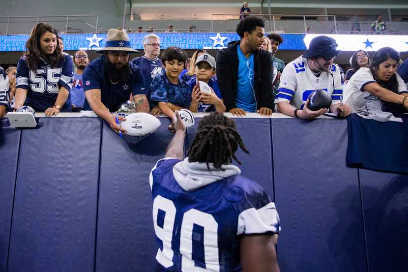 Dallas Cowboys defensive end Demarcus Lawrence (90) signs autographs for fans during a...