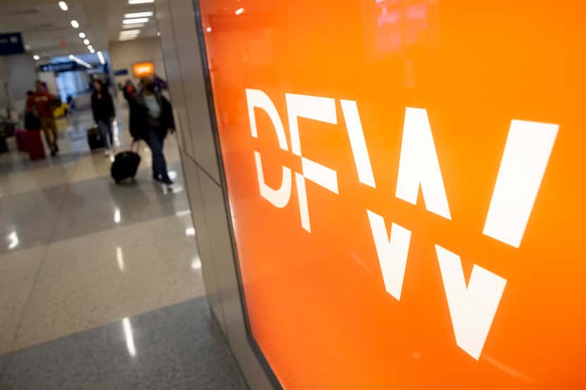 Passengers walk around Terminal D at Dallas/Fort Worth International Airport on Wednesday,...