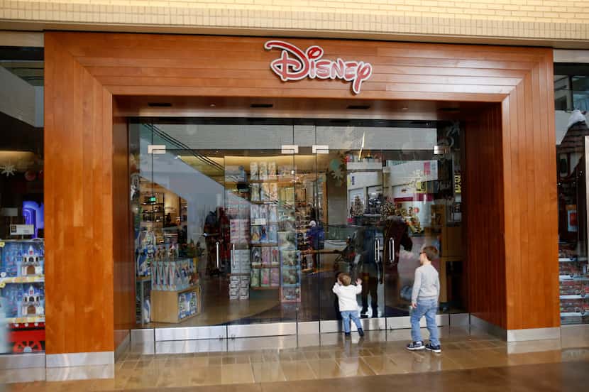 Nicolas Constantine, 5, and his brother Alexander, 1, of Dallas wait for the Disney Store to...