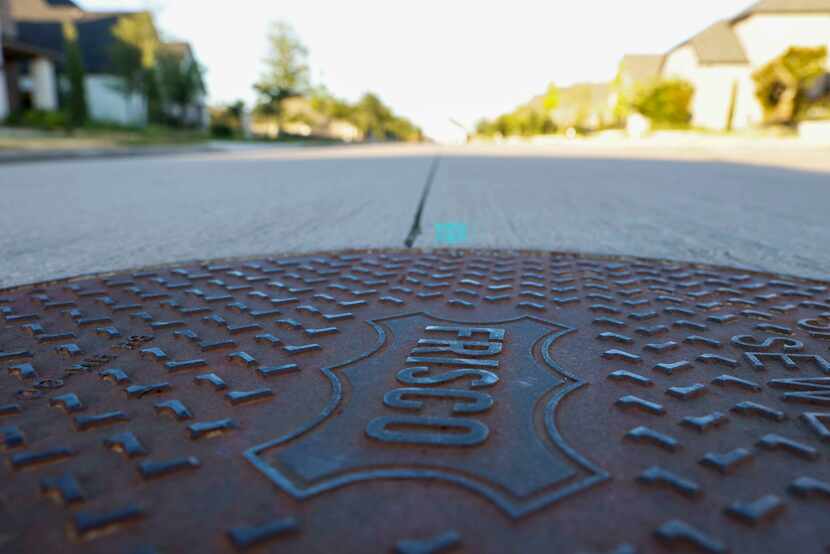 A manhole cover shows "Frisco" in the Estates at Rockhill on June 29, 2022. The neighborhood...