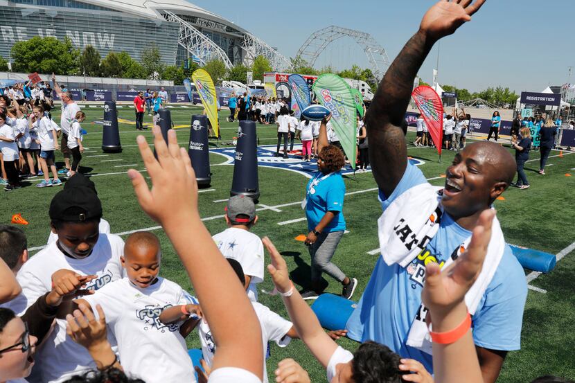 NFL Draft Community Ambassador DeMarcus Ware celebrates with several of the 500 students...